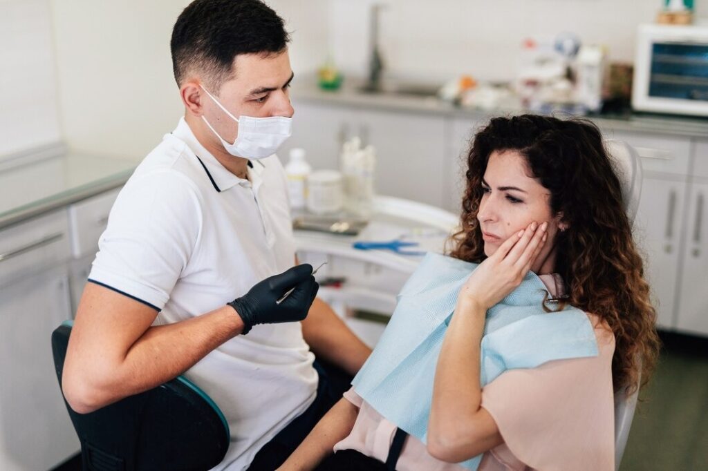 Woman with toothache preparing for wisdom teeth removal recovery at dentist