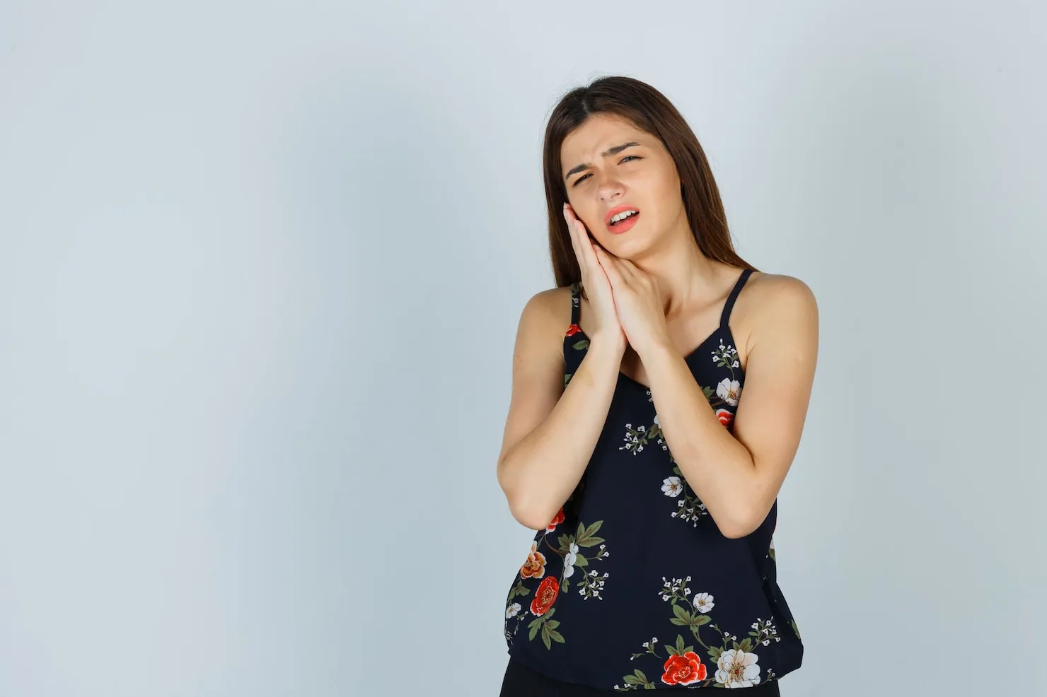 Young lady in floral top suffering tooth pain Wisdom Teeth Removal Sydney