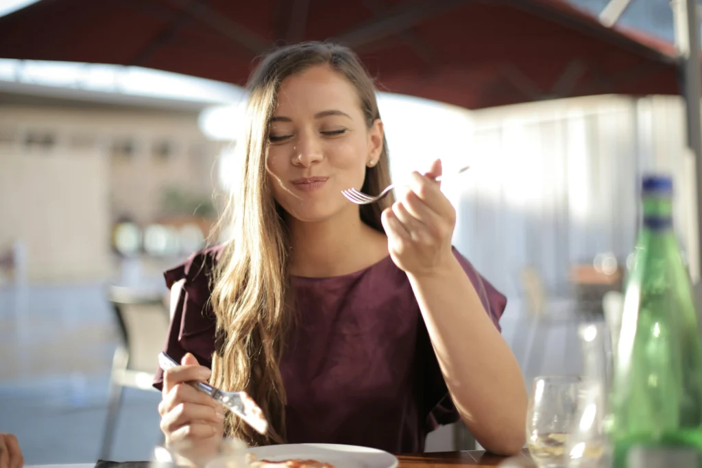 Woman in purple eating soft food during wisdom teeth recovery