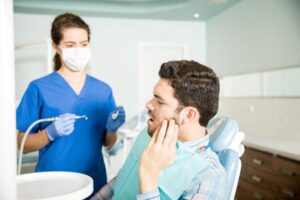 Professional dentist performing tooth pain treatment procedure
