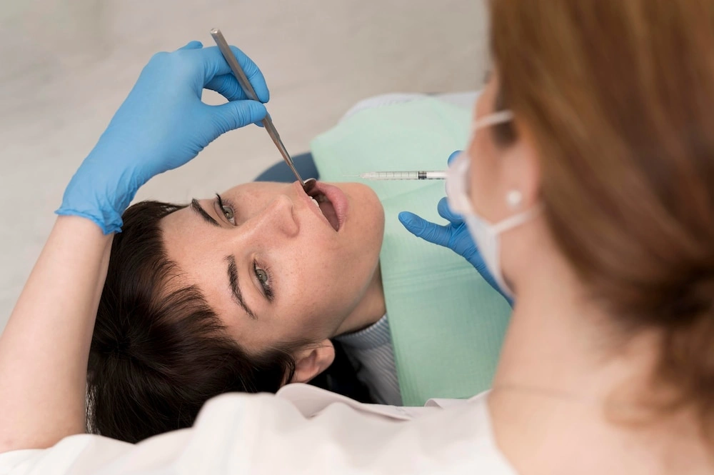 A dentist administering a local anesthetic injection to a female patient before a wisdom teeth removal procedure in Sydney